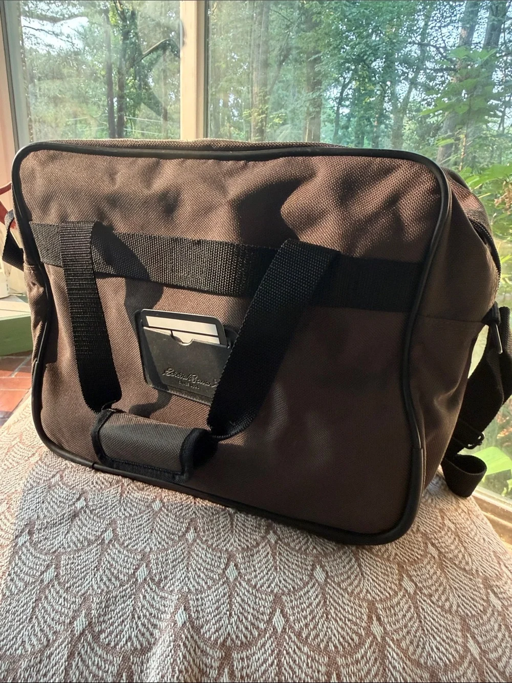 Eddie Bauer army green carry-on bag with black hand straps and shoulder strap